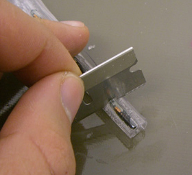 Step 6. Place the tube with the PIT tags glued on over the larger rod so that there is a gap along the split. Spread an ample amount of glue on one side of the split tube, between the cut and the PIT tags. Quickly wrap the other piece of split tubing around the first such that the split in the second (outer) piece of tubing rests against the string of PIT tags (see drawing below). Take care not to get any glue on the other side of the inner tube. Give this assemblage about 10 minutes or longer to dry. 